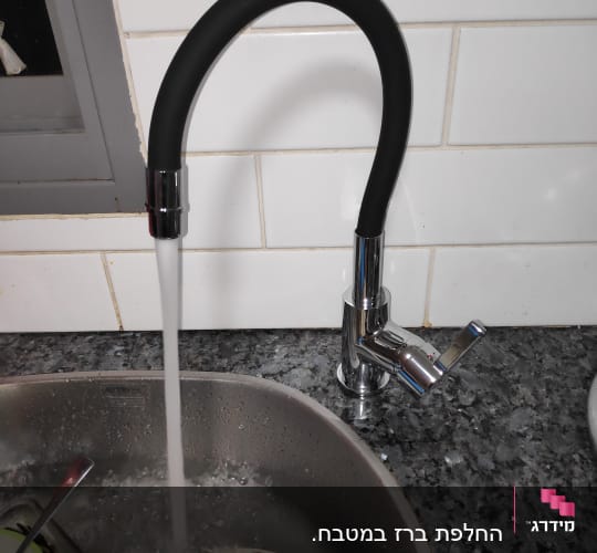 ברז מטבח עם מים זורמים לכיור